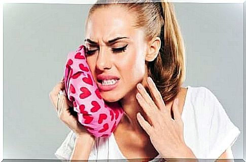 Woman stimulating the relief of toothache with ice