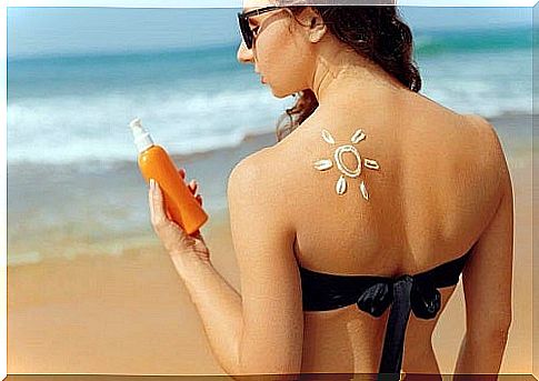 Woman at the beach applying sunscreen